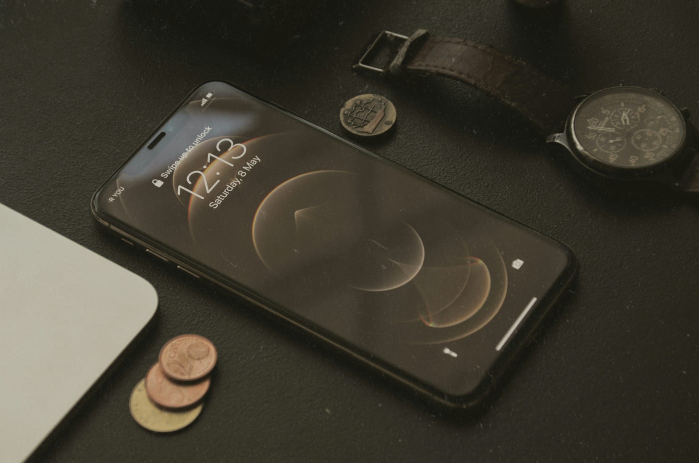 Banknoty i smartfon leżące na stole - symbolizujące opłaty za streaming muzyki